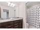 Bathroom boasting double sinks, granite countertops, and a shower with a patterned curtain at 2402 Dubai St, Kissimmee, FL 34747