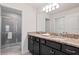 Bathroom featuring dual sinks with granite countertops and a glass-enclosed shower at 2402 Dubai St, Kissimmee, FL 34747