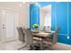 Bright dining room with white table, seating for six, modern lighting, and accent wall at 2402 Dubai St, Kissimmee, FL 34747