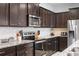 Modern kitchen with stainless steel appliances, granite countertops, and dark cabinets at 2402 Dubai St, Kissimmee, FL 34747