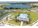 A picturesque aerial view showcases the community pool, playground, and a serene lake in the background at 2715 Rowan St, Tavares, FL 32778