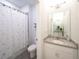 Bright bathroom with granite vanity and a shower with decorative curtain at 2715 Rowan St, Tavares, FL 32778