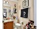 Well-lit bathroom with a granite countertop vanity, decorative mirror, and toilet at 2926 Boating Blvd, Kissimmee, FL 34746