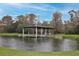 Picturesque pond featuring a covered dock with a seating area on a sunny day at 2926 Boating Blvd, Kissimmee, FL 34746