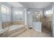 Luxurious bathroom featuring a tiled soaking tub with columns and a glass shower with tile surround at 3123 Bentonshire Pl, Longwood, FL 32779