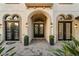 Elegant front entrance with arched doorways, black framed doors and manicured plants at 3123 Bentonshire Pl, Longwood, FL 32779