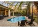 Relaxing pool area with a screened-in enclosure, palm trees, and comfortable seating at 3123 Bentonshire Pl, Longwood, FL 32779