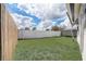 A grassy backyard enclosed with a wooden fence and a white fence at 34936 3Rd Ave, Leesburg, FL 34788