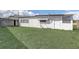 A small grass backyard surrounded by the home and partial fencing at 34936 3Rd Ave, Leesburg, FL 34788