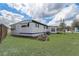 Exterior view of a manufactured home with white siding and a grassy lawn at 34936 3Rd Ave, Leesburg, FL 34788