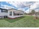 Side exterior view of a white mobile home with awnings and a well-maintained lawn at 34936 3Rd Ave, Leesburg, FL 34788