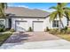 Two-car garage with brick paver driveway and manicured landscaping for a welcoming curb appeal at 3543 Fairwaters Ct # D, Clermont, FL 34711