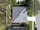 An aerial view of a home showcasing its roof, yard, and proximity to nearby trees and the street at 398 Lake Amberleigh Dr, Winter Garden, FL 34787