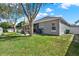 Picture of the fenced backyard, showcasing the patio area, with a lush lawn, and shade trees at 398 Lake Amberleigh Dr, Winter Garden, FL 34787