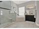 This bathroom features a walk-in shower, soaking tub, black vanity, and neutral tile at 398 Lake Amberleigh Dr, Winter Garden, FL 34787