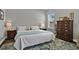 This bedroom features two dressers, a large window, and a floral rug at 398 Lake Amberleigh Dr, Winter Garden, FL 34787