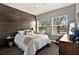 This bedroom features a wood accent wall, two windows, and wood-look floors at 398 Lake Amberleigh Dr, Winter Garden, FL 34787