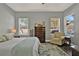 This bedroom features two large windows, a dresser, and a chair at 398 Lake Amberleigh Dr, Winter Garden, FL 34787