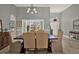 Bright dining room with a large wooden table and views of the outdoors through expansive windows at 398 Lake Amberleigh Dr, Winter Garden, FL 34787