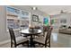 Bright dining area featuring a round wood table and natural light through large windows at 398 Lake Amberleigh Dr, Winter Garden, FL 34787