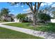 Well maintained single story home with a lawn, mature trees, and a two-car garage at 398 Lake Amberleigh Dr, Winter Garden, FL 34787