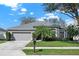 Charming single-story home with a well-maintained lawn, mature trees, and a two-car garage at 398 Lake Amberleigh Dr, Winter Garden, FL 34787