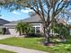 Single-story home with a well-maintained lawn, mature trees, and a two-car garage at 398 Lake Amberleigh Dr, Winter Garden, FL 34787