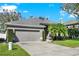 Single-story home with a well-maintained lawn, mature trees, and a two-car garage at 398 Lake Amberleigh Dr, Winter Garden, FL 34787