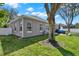 Beautiful neutral exterior of the home with a well-maintained lawn, patio area, and mature shade trees at 398 Lake Amberleigh Dr, Winter Garden, FL 34787