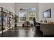 Bright home office featuring dark wood floors, modern shelving, and ample natural light at 398 Lake Amberleigh Dr, Winter Garden, FL 34787