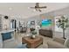 Bright living room with a decorative stone wall, large windows, and a neutral color palette at 398 Lake Amberleigh Dr, Winter Garden, FL 34787