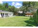 Expansive backyard with lush lawn, patio seating, and manicured landscaping provides a serene outdoor living space at 420 Sylvan Dr, Winter Park, FL 32789