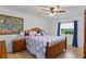 Bedroom with hardwood floors, full bed, a ceiling fan, and a blue accent wall with matching curtains and pillows at 420 Sylvan Dr, Winter Park, FL 32789