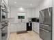 Well-lit kitchen featuring stainless steel appliances, white cabinetry, and ample counter space at 420 Sylvan Dr, Winter Park, FL 32789