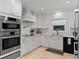 Well-lit kitchen featuring stainless steel appliances, white cabinetry, and ample counter space at 420 Sylvan Dr, Winter Park, FL 32789