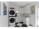 Well-organized laundry room with stacked washer/dryer, black and white tile floors, and ample storage space at 420 Sylvan Dr, Winter Park, FL 32789