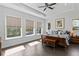 Sunlit main bedroom with tray ceilings, wood floors, and large windows offering serene views at 420 Sylvan Dr, Winter Park, FL 32789