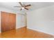 Cozy bedroom with wood floors, ceiling fan, closet, and a white door at 4212 Lake Underhill Rd # 5, Orlando, FL 32803