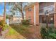 Brick building featuring screened patios, lots of greenery, and a white fence at 4212 Lake Underhill Rd # 5, Orlando, FL 32803