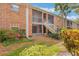 Charming brick building with screened patios and stairs leading to a lush garden at 4212 Lake Underhill Rd # 5, Orlando, FL 32803