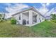 Exterior shot of a home featuring a manicured lawn, covered patio, and outdoor seating area at 4426 Davos Dr, Clermont, FL 34711