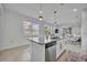 Open-concept kitchen island with stainless steel dishwasher, granite counters, and pendant lighting at 4426 Davos Dr, Clermont, FL 34711