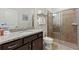 Bright bathroom features granite countertop vanity and a glass-enclosed shower with a shower head at 4607 Terrasonesta Dr, Davenport, FL 33837