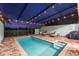 A covered pool with chairs on a brick patio and a view of trees and the evening sky at 4607 Terrasonesta Dr, Davenport, FL 33837