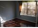 Bedroom with hardwood floors, blue walls, natural light, and window with beige and green curtains at 4650 Redmond Pl, Sanford, FL 32771