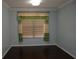 Bedroom with dark wood floors and a window featuring decorative curtains and blinds at 4650 Redmond Pl, Sanford, FL 32771