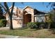 Exterior front view showcasing the two-story house, attached garage, arched entryway, landscaped yard, and healthy green lawn at 4650 Redmond Pl, Sanford, FL 32771