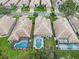 An aerial shot shows a residential neighborhood featuring mature trees and fenced-in pools and backyards at 501 Sotheby Way, Debary, FL 32713