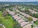 An aerial view showing a residential neighborhood near a golf course, and a beautiful pond at 501 Sotheby Way, Debary, FL 32713