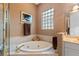 This bathroom showcases a soaking tub, walk-in shower and a unique glass block window at 501 Sotheby Way, Debary, FL 32713